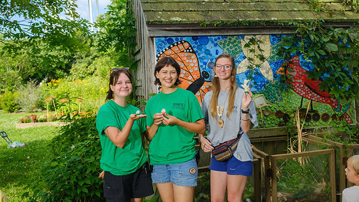 Three student interns stand in the Kentucky Children's Garden