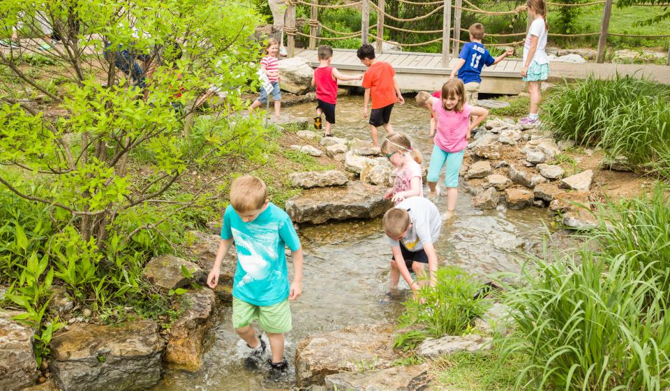 Kids playing in a creek at the Kentucky Children's Garden