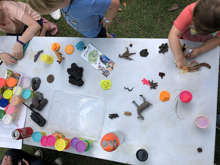 Kids learning and playing with items on a table in the Garden